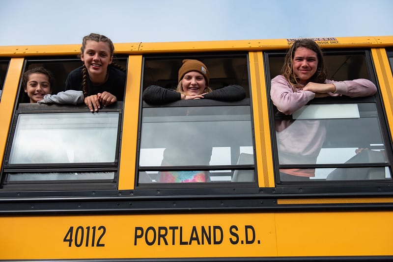 Photograph of children on a bus looking out the windows headed to OMSI outdoor school.