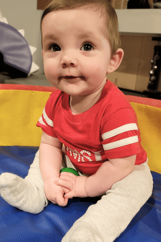 Baby in red OMSI onesie playing in the Science Playground